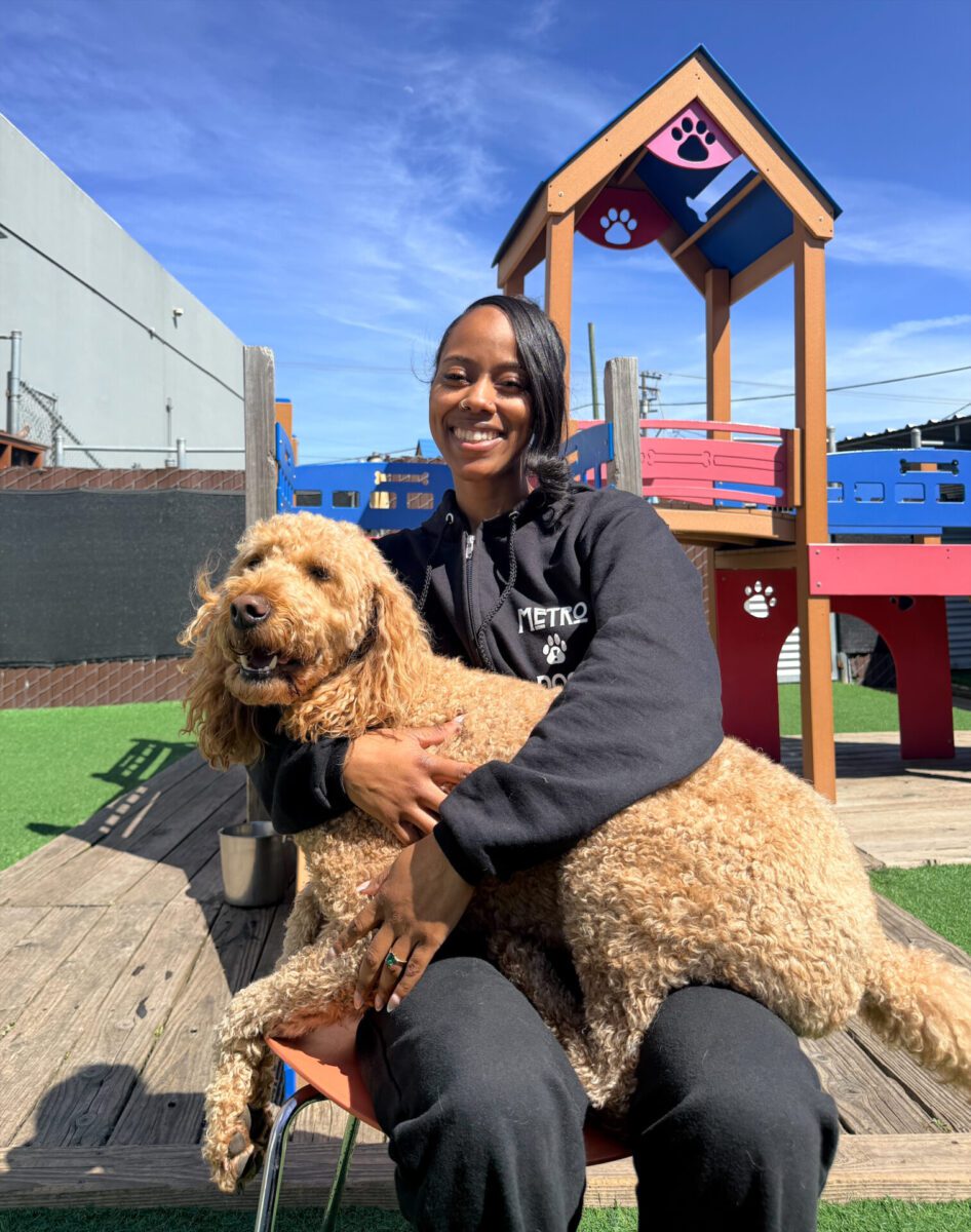 metro dog team member Kiani holding a dog in her lap